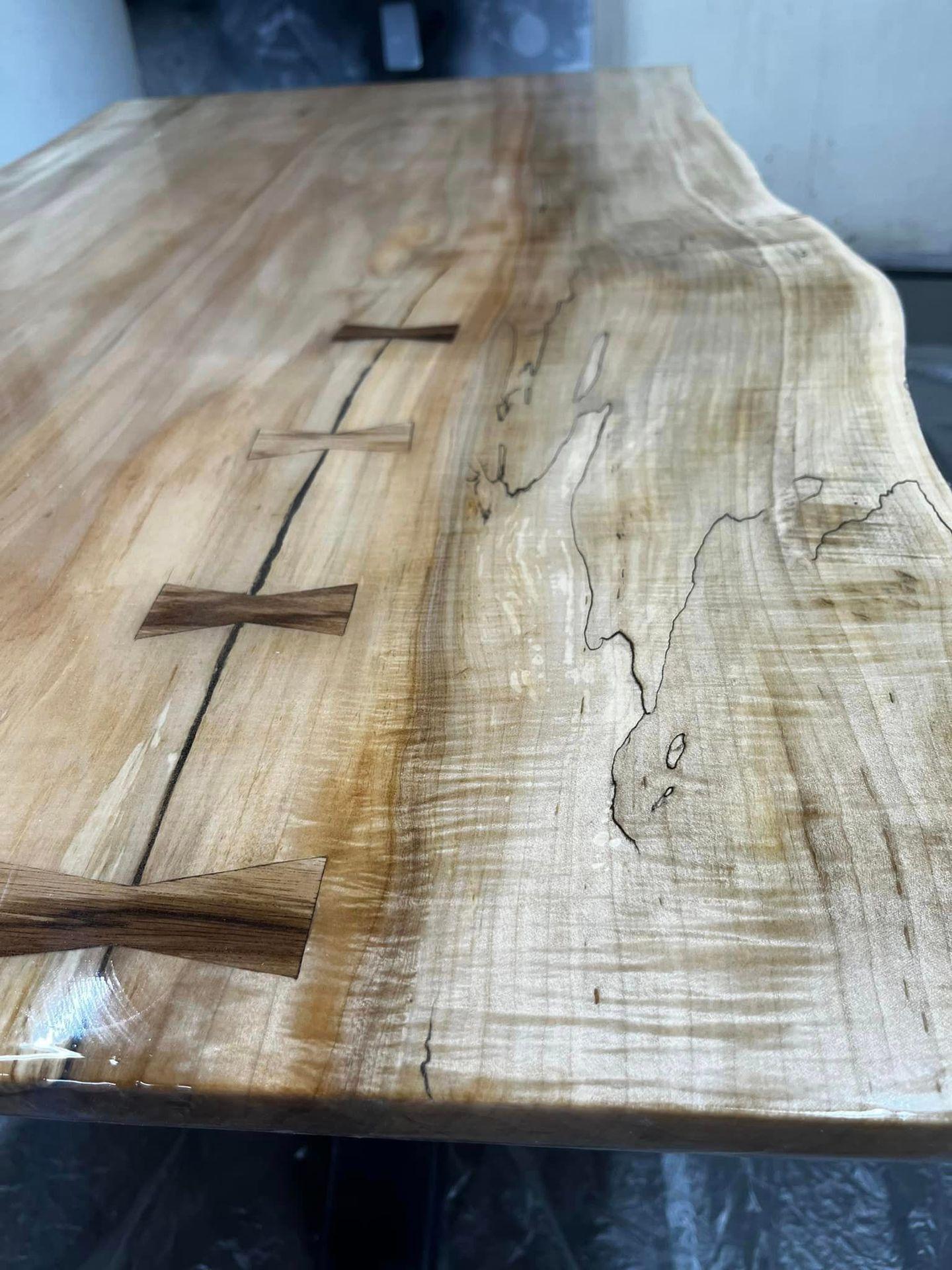 Close-up view of a wooden table with unique grain patterns and butterfly joint inlays.